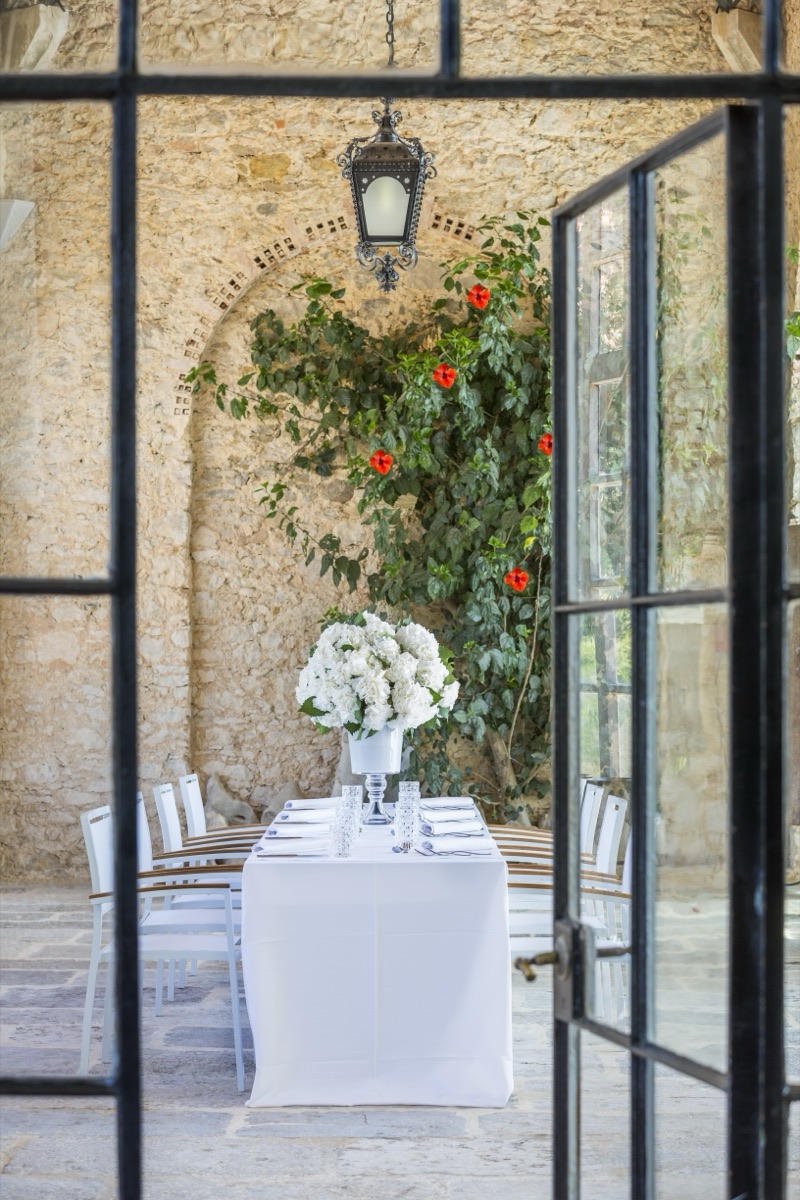 A courtyard table behind the steel-framed doors of Forte da Cruz